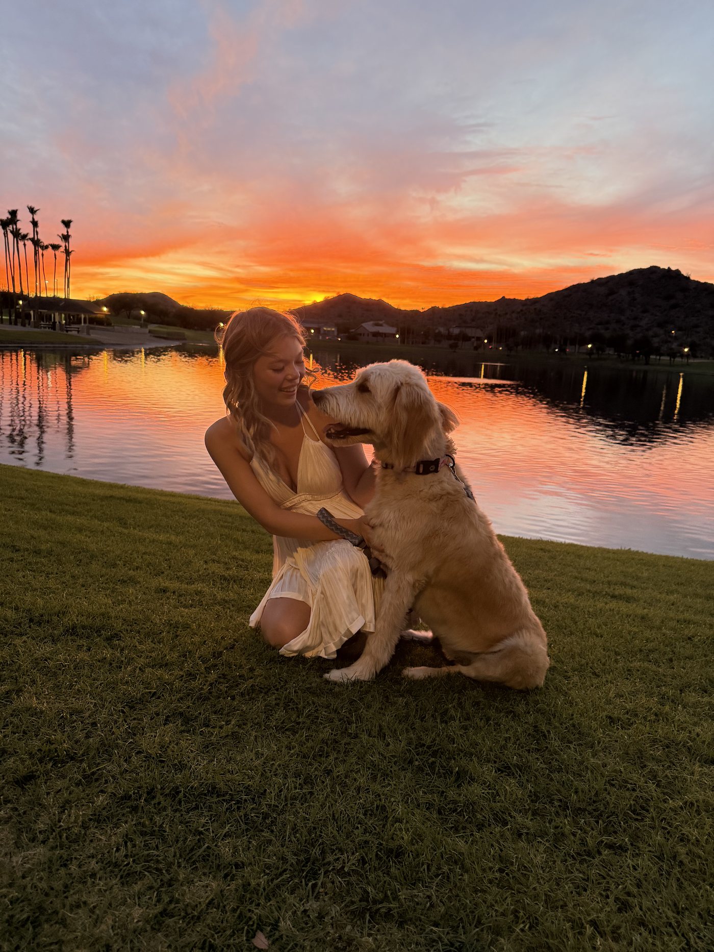 Abri kneeling with her dog at sunset